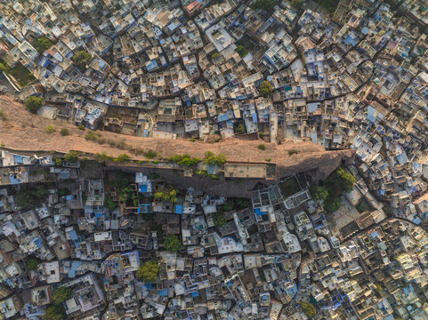 Aerial view of the vibrant and historic cityscape with colorful rooftops and ancient fort walls, Jodhpur, India.