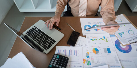 Analyzing financial data office setting business report contemporary workspace overhead view...