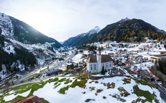 Aerial view of the beautiful Church of Wassen surrounded by snow-capped mountains in a scenic winter landscape, Wassen, Switzerland.