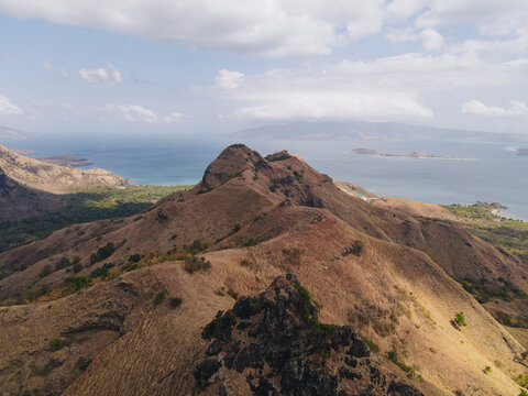 Aerial drone landscape view of Golo Mori island mountain peak in Labuan Bajo, Indonesia.