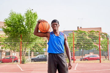 Fototapeta premium A man in a blue shirt is holding a basketball.