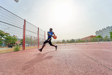 black basketball player dunking on an outdoor court