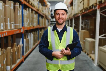 Portrait of warehouseman with clipboard checking delivery, stock in warehouse. Warehouse worker...