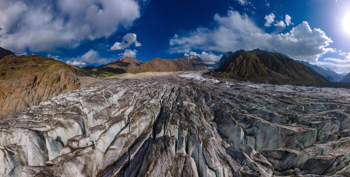Aerial view of majestic Chatibo Glacier surrounded by rugged mountains and a vast sky, Upper Chitral, Pakistan.