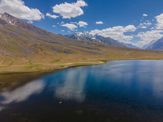 Aerial view of beautiful Shandur Lake surrounded by majestic mountains and a serene valley, Shandur, Pakistan.