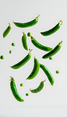 Green peas in mid-air against a plain white background  -