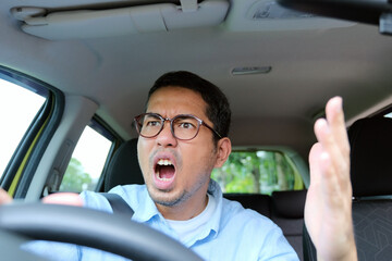 A car driver showing angry gesture when driving his car