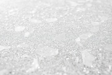 Obraz premium Close-up of a white glitter texture, with a bright silver shimmer on a clean grey background. 