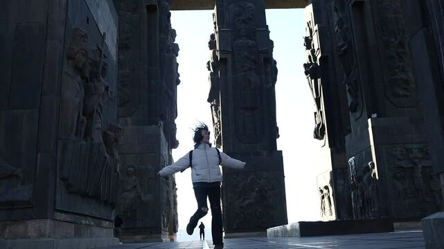 A beautiful girl visits a Georgian landmark. The girl is a tourist. Chronicles of Georgia monument