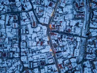 Snow-covered rooftops create a stunning winter landscape in a quaint Bansko town at twilight
