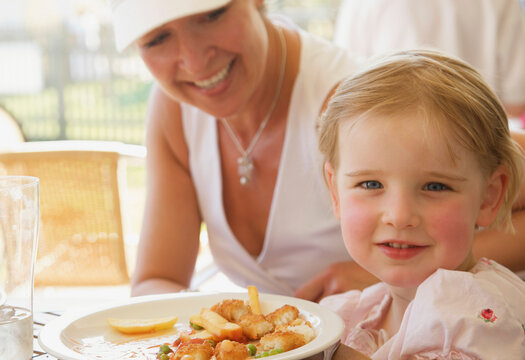 Woman and her daughter eating at a restaurant
