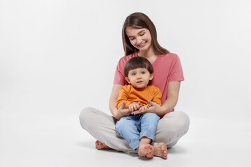 Happy mother with her cute little son on white background. Space for text