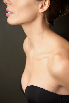 Close up profile of a young woman wearing a strapless black bra
