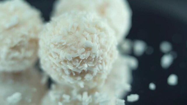 Macro shot of tasty Raffaello bonbons on a rotating stand, coconut dessert, white coco dessert, smooth movement 120 fps slow motion video
