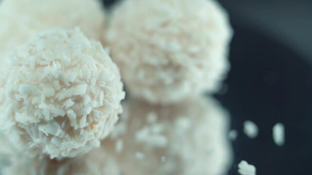 Macro shot of tasty Raffaello bonbons on a rotating stand, coconut chips, white coco balls, smooth movement 120 fps slow motion video