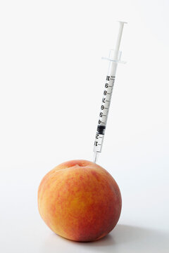 Hypodermic Needle Inserted in a Peach
