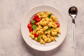 Sacсhettini pasta in a plate with tomato sauce.