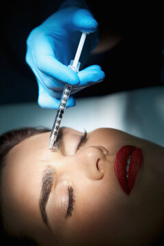 Woman Receiving Botox Injection on Forehead - Close-up view
