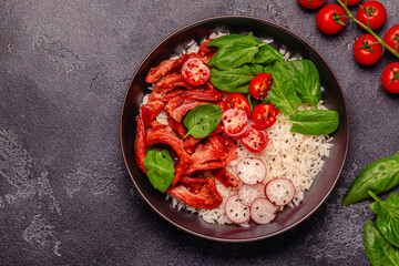 Bowl with vegan fried soy meat and vegetables served with boiled rice.
