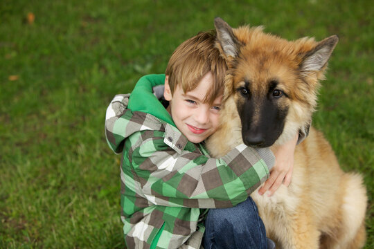 Boy Hugging Alsatian Puppy
