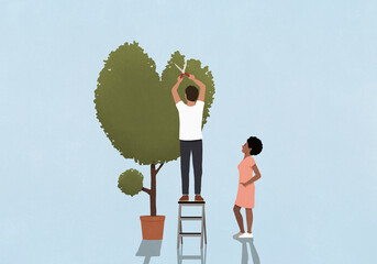 Woman watching boyfriend trim heart-shape tree on blue background
