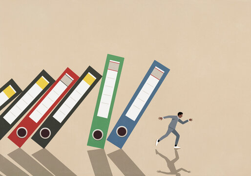 Businessman running from falling binders on beige background
