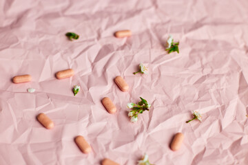 Overhead View of Multiple Blister Packs of Medication on a Crumpled Pink Surface