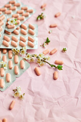Overhead View of Multiple Blister Packs of Medication on a Crumpled Pink Surface