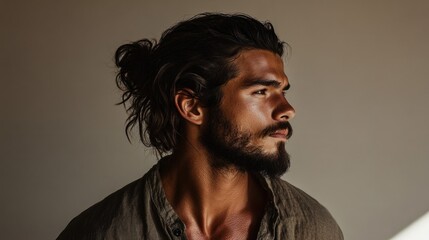 Contemplative man with beard looking away in minimalist setting. Hair identity, diversity