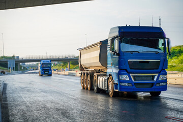 A dump truck driving on a freshly paved highway, showcasing the smooth asphalt surface and the role...