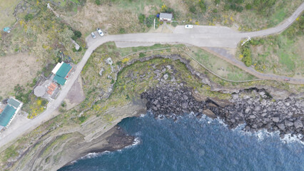 The beautiful harmony of Songaksan Dulle-gil, the sea, and cliffs in Jeju Island, Korea, and the natural scenery taken from the sky with drones
