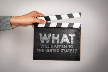 Obraz premium What will happen to the United States. Female hands holding movie clapper.
