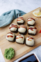 sushi rolls with baked cheese, unagi sauce, sesame, lemon, soy sauce, ginger, wasabi, sushi set on a light background, still life, food, Japanese cuisine, flatlay