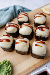 sushi rolls with baked cheese, unagi sauce, sesame, lemon, soy sauce, ginger, wasabi, sushi set on a light background, still life, food, Japanese cuisine, flatlay