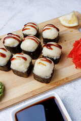 sushi rolls with baked cheese, unagi sauce, sesame, lemon, soy sauce, ginger, wasabi, sushi set on a light background, still life, food, Japanese cuisine, flatlay