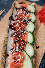 sushi dog, rolls with rice, nori, salmon, unagi sauce, sesame, fresh cucumber, with ginger, wasabi, soy sauce, flatlay, Japanese food, fast food, snacks