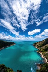 Fototapeta premium Puffy white clouds drifting over a turquoise ocean, casting shadows on the water,