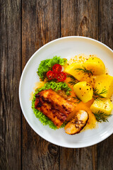 Baked rabbit saddle and boiled potatoes on wooden table