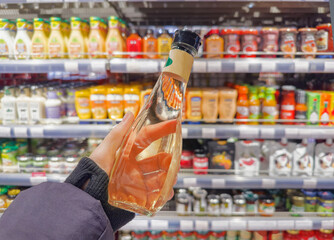 choosing olive oil, sauce, vinegar at the grocery store