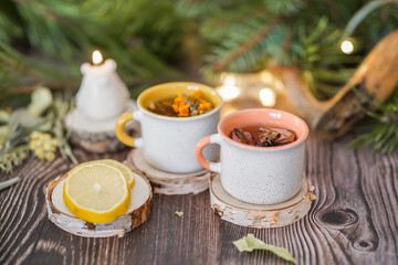 Cozy winter vibes with herbal tea, dried citrus slices, and seasonal decor – Christmas lights and fir tree branches