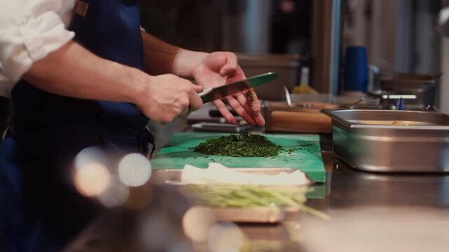 A professional chef chopping fresh herbs in a busy kitchen, preparing ingredients for a meal. The scene captures the focus and craftsmanship of culinary work in a vibrant restaurant setting