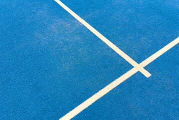  r sport concept with padel tennis ball on white line on padel tennis court blue color. Flat lay, top view, copy space, close up.