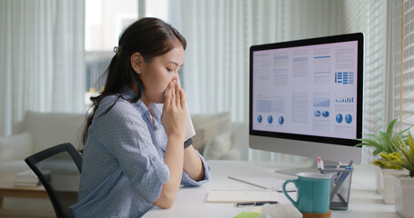 Asia people young lady remote workforce work on leave day got bad cold flu covid cough blow running nose on tissue paper sit on desk at home office. Tired unwell female freelance staff stress pain.