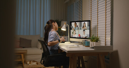 Young asia female busy late night work hard video call online remote group talk stiff neck relief pain ache sit on desk computer in chronic suffer burnout brownout office syndrome workforce at home.