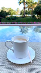 Coffee cup on reflective glass table, coffee blending with reflections of palm trees outdoor greenery, creating serene outdoor ambiance where reflections and calm moments invite peaceful relaxation 