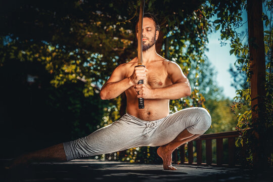 Athletic man practicing with a sword.
