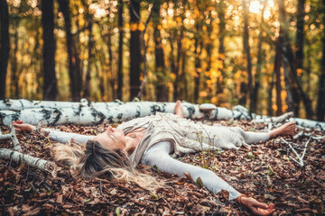 A Woman Joyfully Embracing the Beauty of Nature While Surrounded by Autumn Leaves