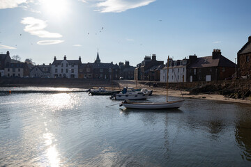 Scenic view of Stonehaven harbor with boats and historical architecture under a bright sky