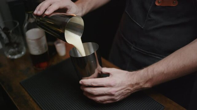 Home bartender mixing cocktails with flair. Perfect for promoting mixology classes or cocktail recipe videos.