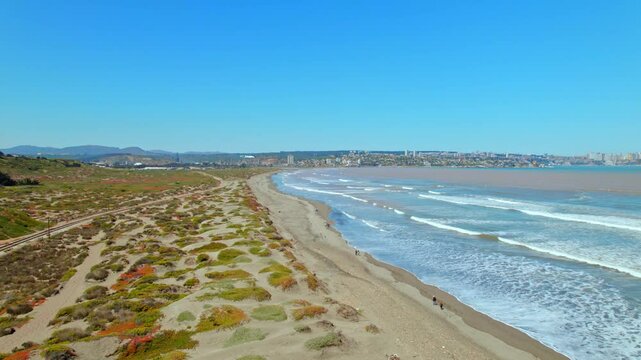 Aerial view establishing of Punta de Piedra beach in Quintero Chile, sunny and clear day, beach with dark color.